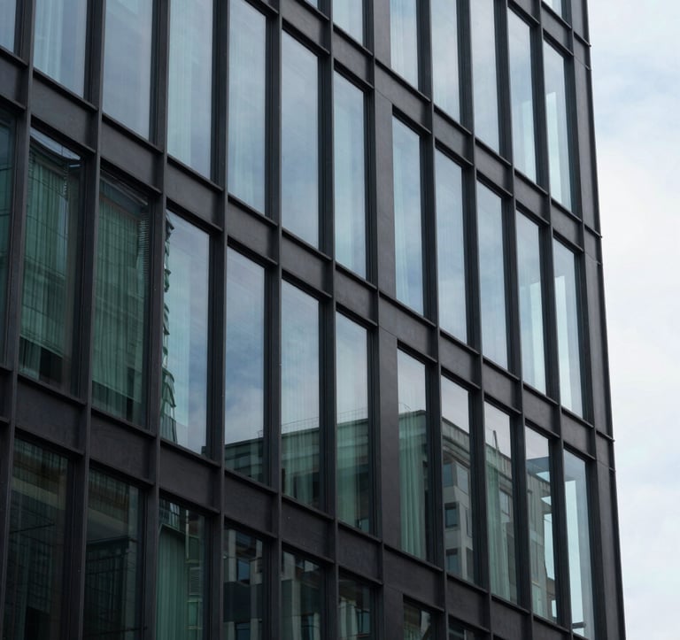A close-up shot of an architecturally impressive modern building made of glass and steel, reflecting a clear sky. The style is minimalist and high-end, incorporating dark charcoal and forest green reflections, symbolizing stability and modernity.