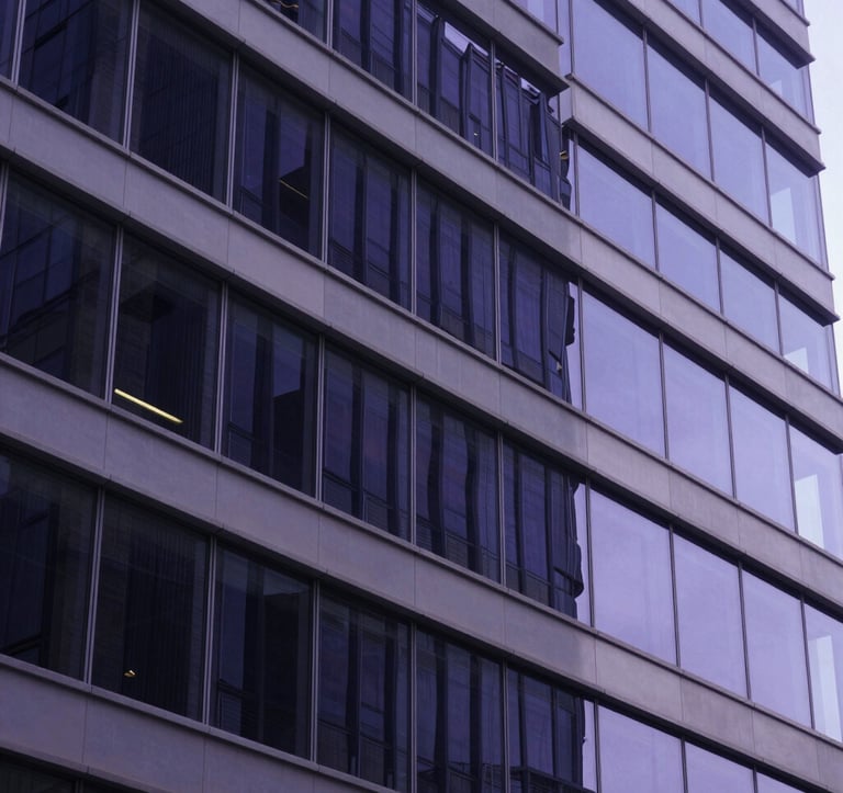 Abstract photography of a modern architectural structure with glass and metal reflecting deep navy and purple light. The composition is clean and sharp, conveying stability and scalable growth. North American / US corporate setting.