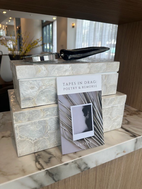 paperback book tapes in drag: poetry & remorse leaning on luxurious boxes