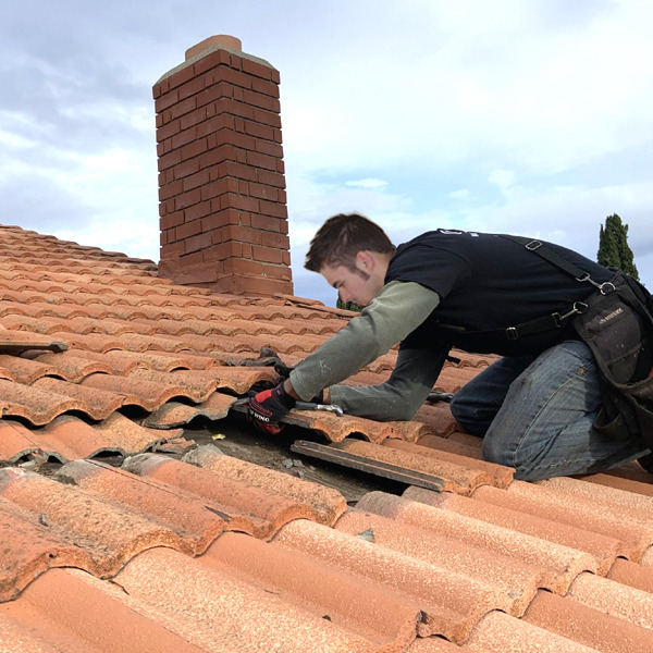 Working on a roof replacing tiles