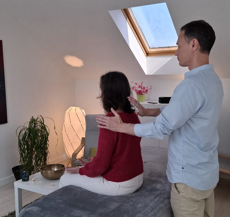 Femme assise recevant un soin énergétique dans un cabinet chalereux.