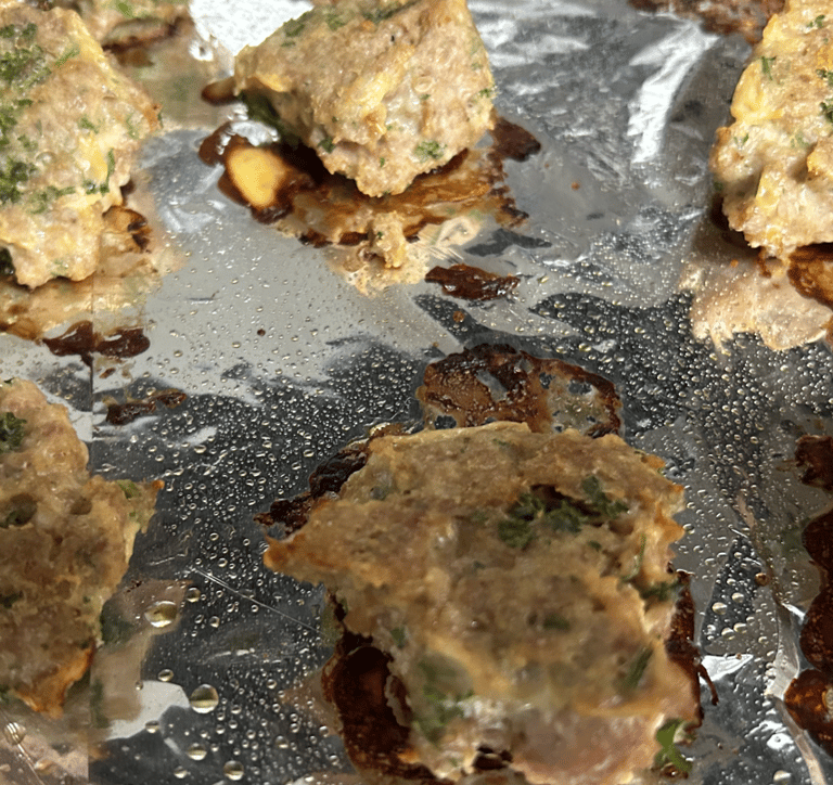 Turkey meatballs on pan covered in foil just after cooking in oven.