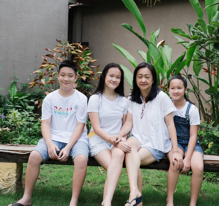 Family sitting together during extended family photography session at Lumbini Villas Jimbaran Bali in garden setting