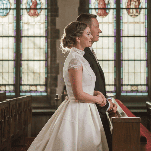 a bride and groom standing in front of a church