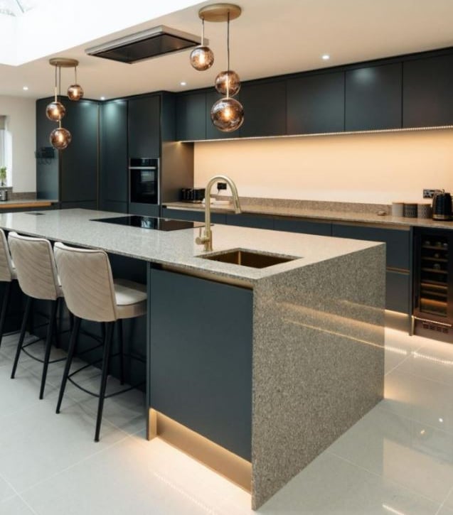 Cuisine moderne sur mesure avec îlot central, plan de travail en pierre et finitions haut de gamme à
