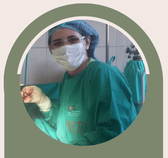 Uma médica com jaleco verde está realizando um procedimento cirúrgico