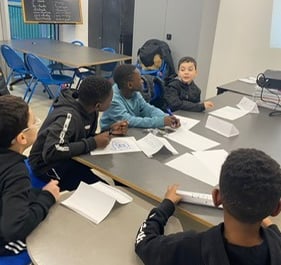 a group of children sitting around a table