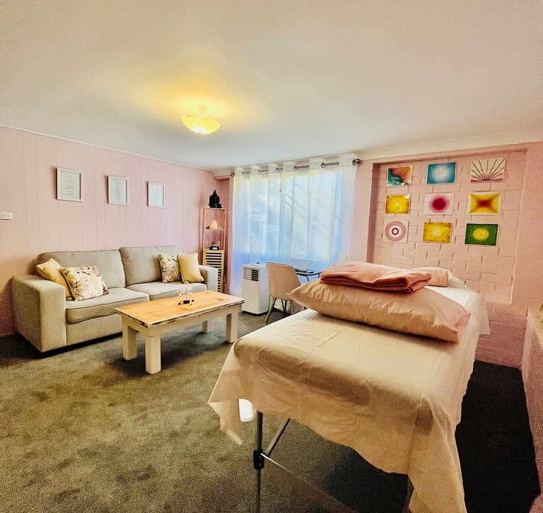 healing room with table, couch and massage table in pink