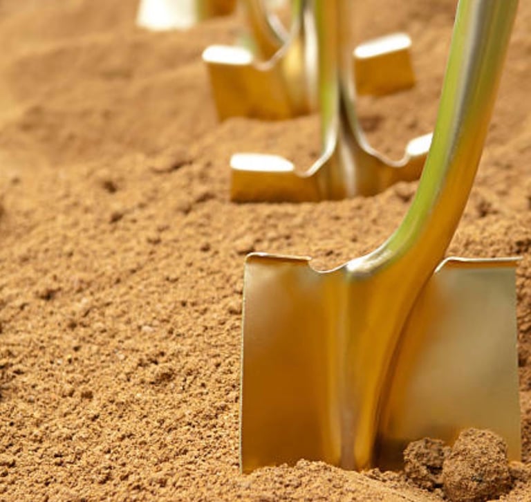 gold spades lined up in tanned earth waiting for the internment proceedings to start