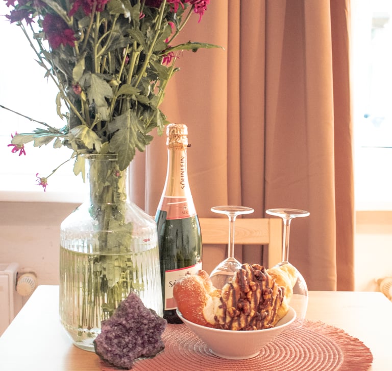 a table with a bowl of food and a bottle of wine