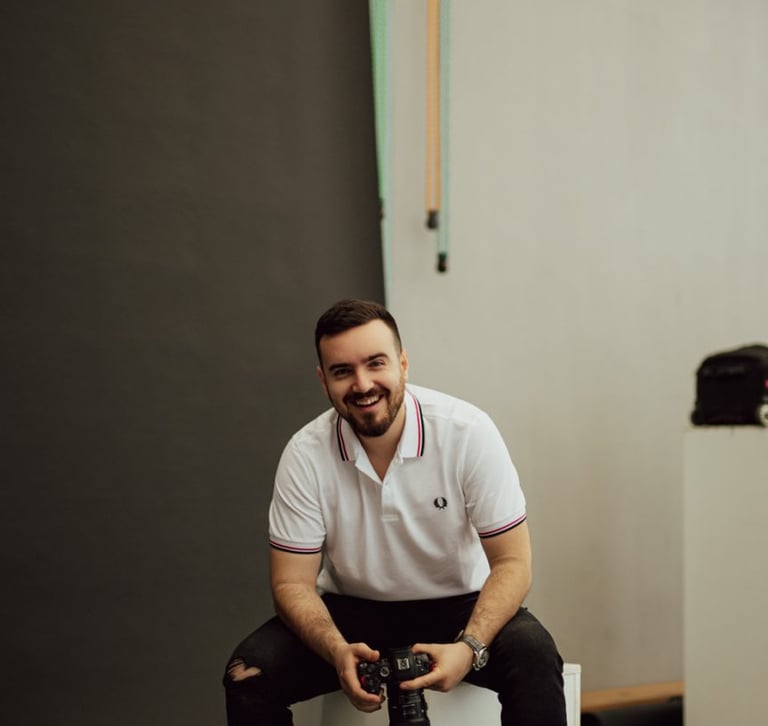 a man sitting on a white cube with a camera