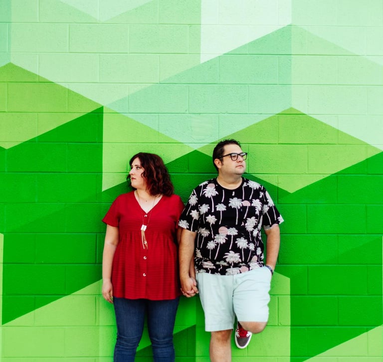 Alamosa Consulting founders man and woman pose in front of a mural