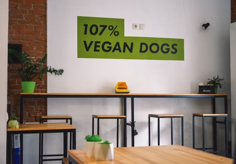 immagine di ristorante con insegna verde che indica 107% cani vegani usato per marketing ingannevole