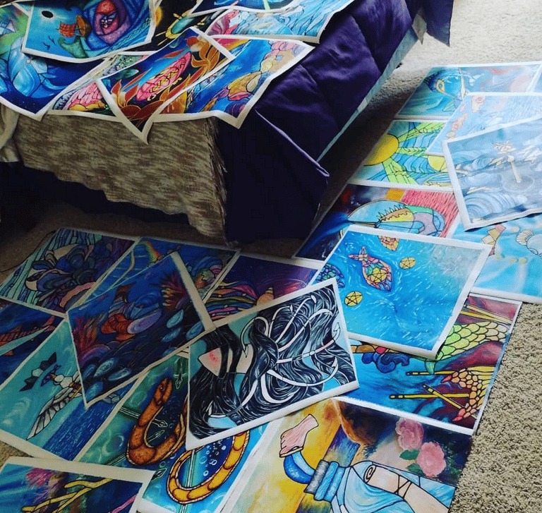 Photo of completed paintings on loose canvas spread out over artists's bedroom floor