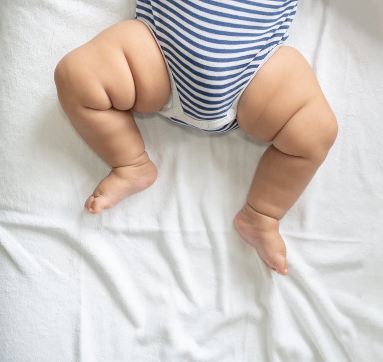 jambes d'un bébé en body