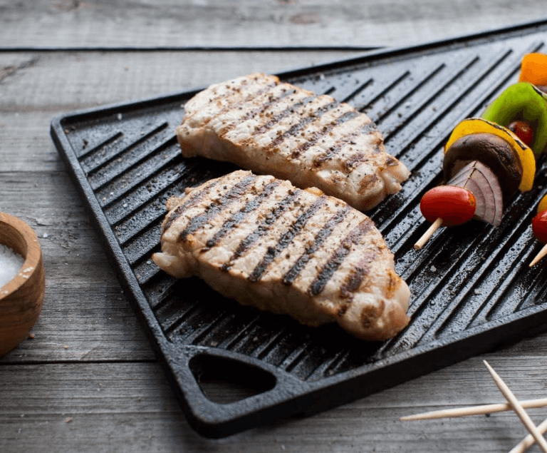 a grilling pan with meat and vegetables on it