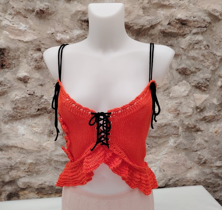 Caraco tricoté dans un fil coton orange avec des liens noir