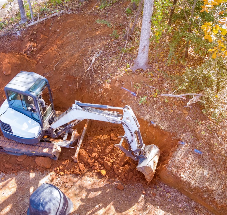 mini-excavator-digging-out-hillside.png