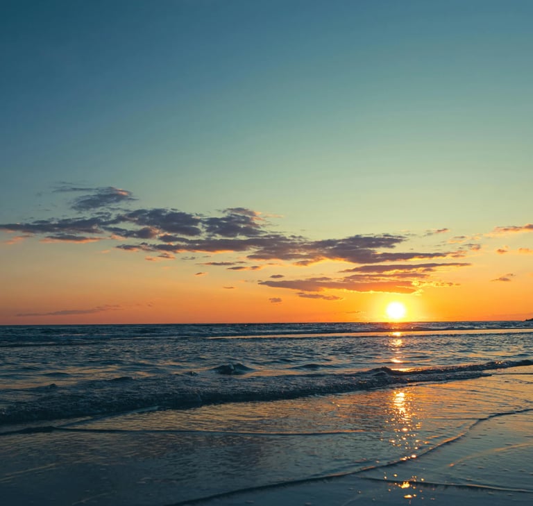 Un tramonto bellissimo visto dalla spiaggia, il sole che scompare nel mare