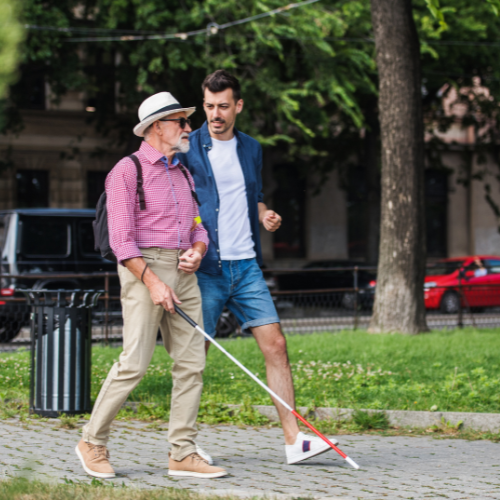 Man with macular degeneration and cane for the blind traveling in a big city