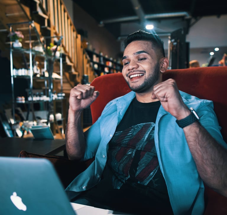 a guide man sitting in a chair with a laptop