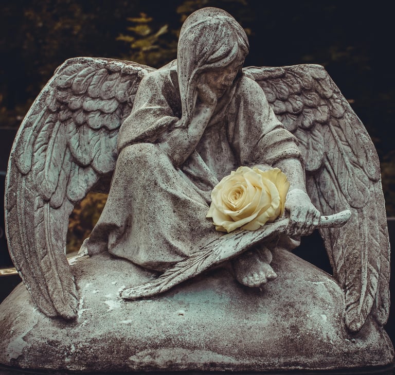 One angel in stone with a white rose. Julia Kadel-unsplash