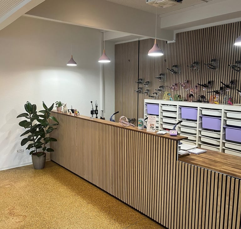 Werkbank-Tresen mit Maulkörben an der Wand, Pflanze im Vordergrund – Beratung im Retro-Stil im Maulk