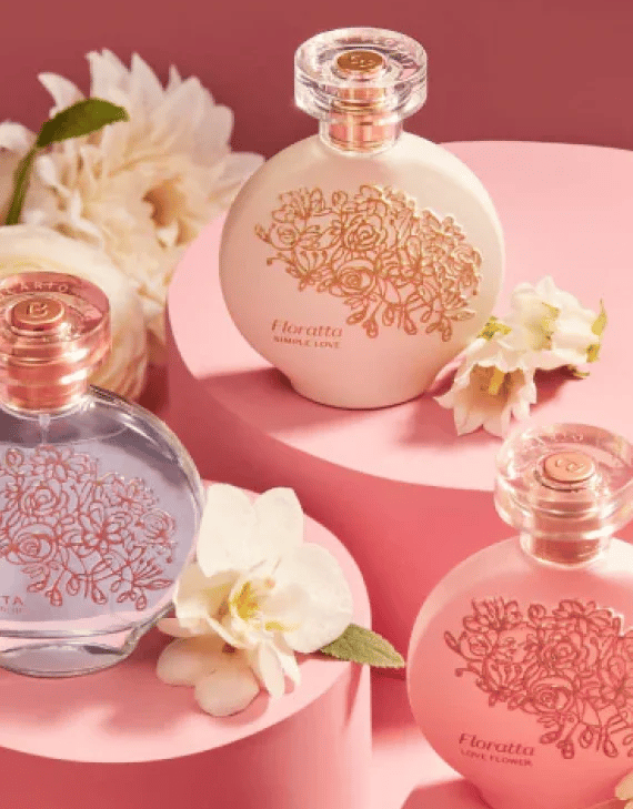 Elegant Floratta perfume bottles with floral engravings on pink pedestals with white flowers.