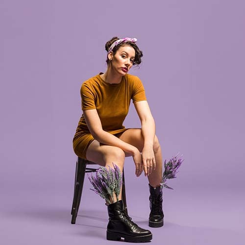 a woman in a short dress and boots with flowers