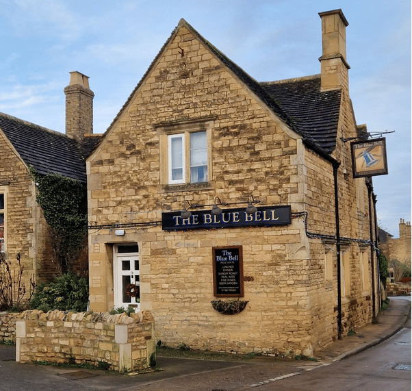 a rural stone building with a sign that says the blue bell