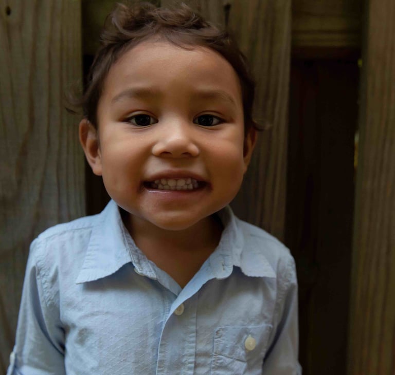 A young boy smiling at the camera.