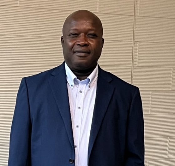a man in a suit and tie standing in front of a wall