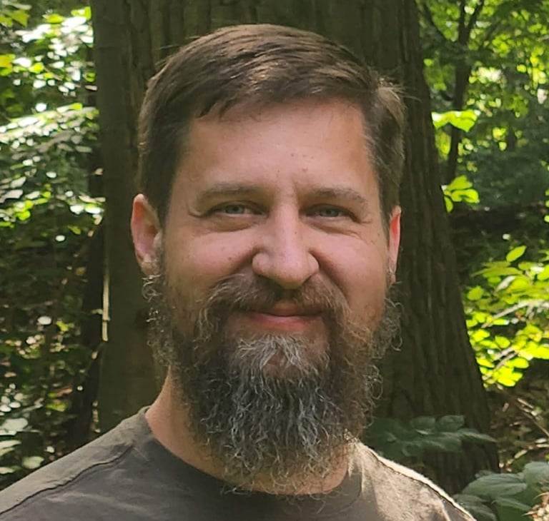 Donald Paul Owens II smiling in green forest