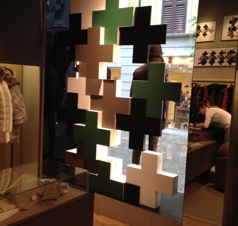 Allestimento vetrina con elementi tridimensionali a forma di croci sovrapposte- AMK Solutons