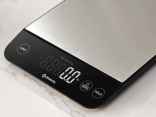 Stainless steel digital kitchen scale with a black display panel showing a zero measurement on a lig