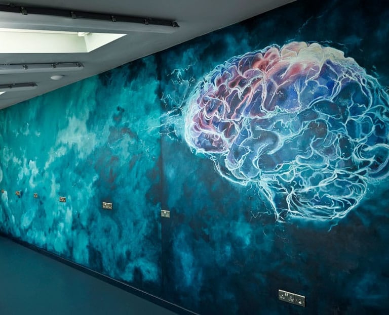  A vibrant brain logo spans the wall, embodying the spirit of creativity and continuous brainstorming in a Cambridgeshire R&D