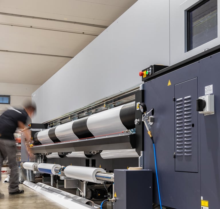a man in a factory with a large machine