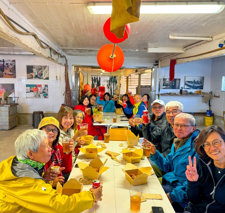 Gjester som spiser fish and chips sammen ved langbord hos Maritime Munchies i Lofoten
