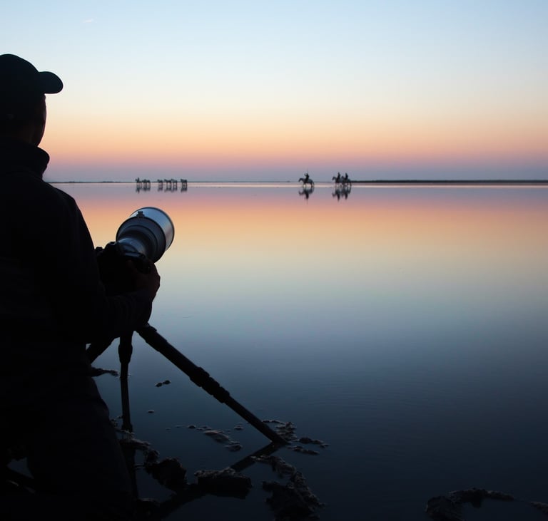 a photographer with a hat and holding a camera