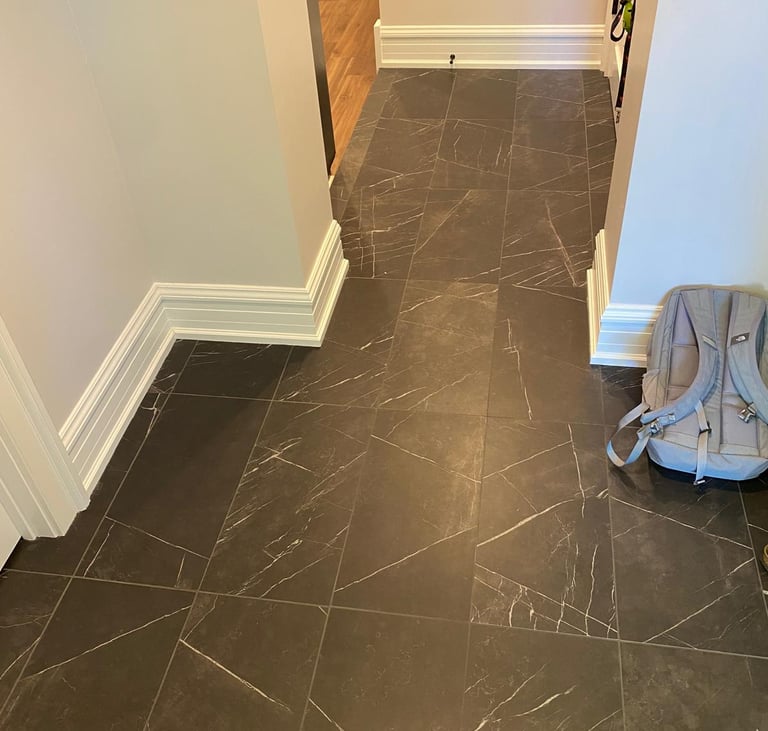 Basement hallway with natural stone flooring leading to finished living and storage areas