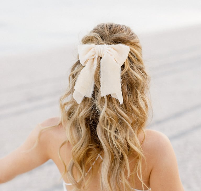 Blonde fashionista bride wears short wedding dress, silk hair bow and natural hair extensions
