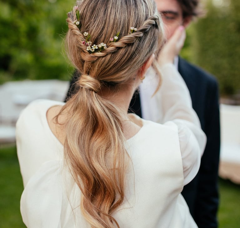 Bride with effortless natural ponytail decorated with natural flowers during wedding in Portugal