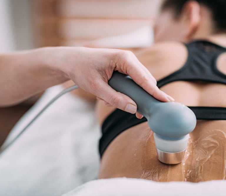 Woman receiving ultrasound physiotherapy on her back