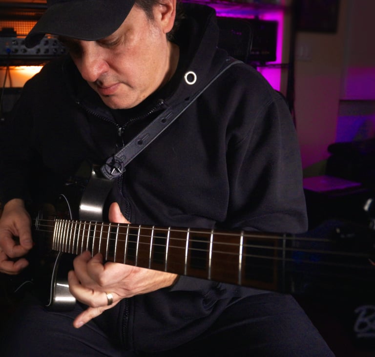 A man in a black hoodie plays an electric guitar in a professional music studio - Lonely Rocker