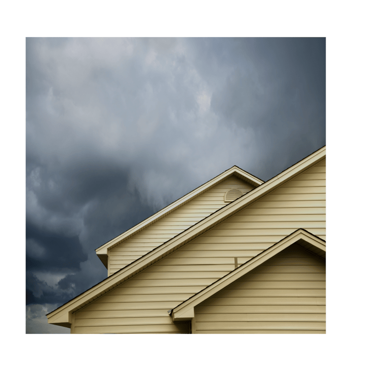 alt="Storm-ready Long Island home exterior showing roof and siding under cloudy sky"