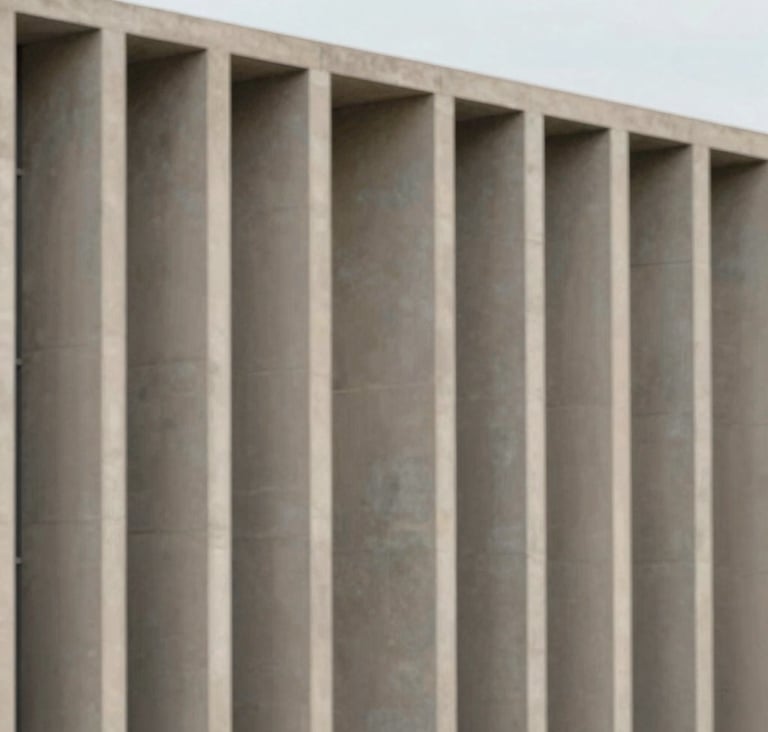 A minimalist, large-scale shot of a building facade featuring clean vertical concrete columns in #D9D2C7 sand tones against a clear, soft sky. Sophisticated architectural photography with precise symmetry.