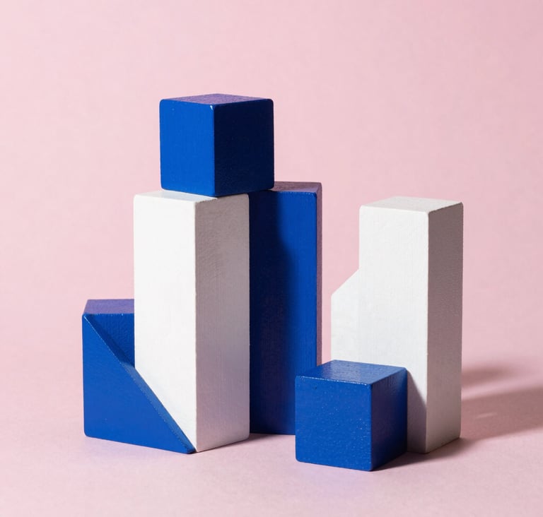 Still life photography of geometric wooden blocks painted in cerulean blue and white against a soft pink backdrop. Professional studio lighting with sharp, artistic shadows, reflecting Bauhaus precision in a North American / US setting.