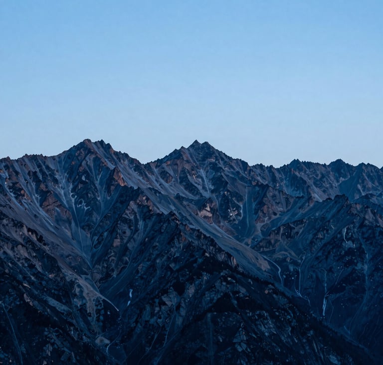 A panoramic alpine landscape at dusk, featuring sharp mountain peaks in steel blue and deep charcoal against a pale ice blue sky, clean minimalist composition, high-end fine art photography, International / Western.