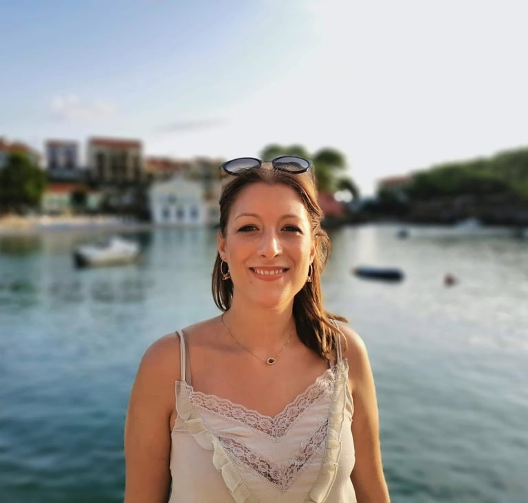 a woman in a white dress and sunglasses on a boat