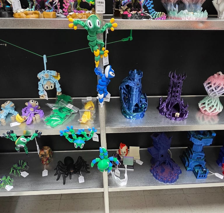 A retail shelf display featuring colorful 3D printed toys, articulated monkeys, and fantasy dice towers.